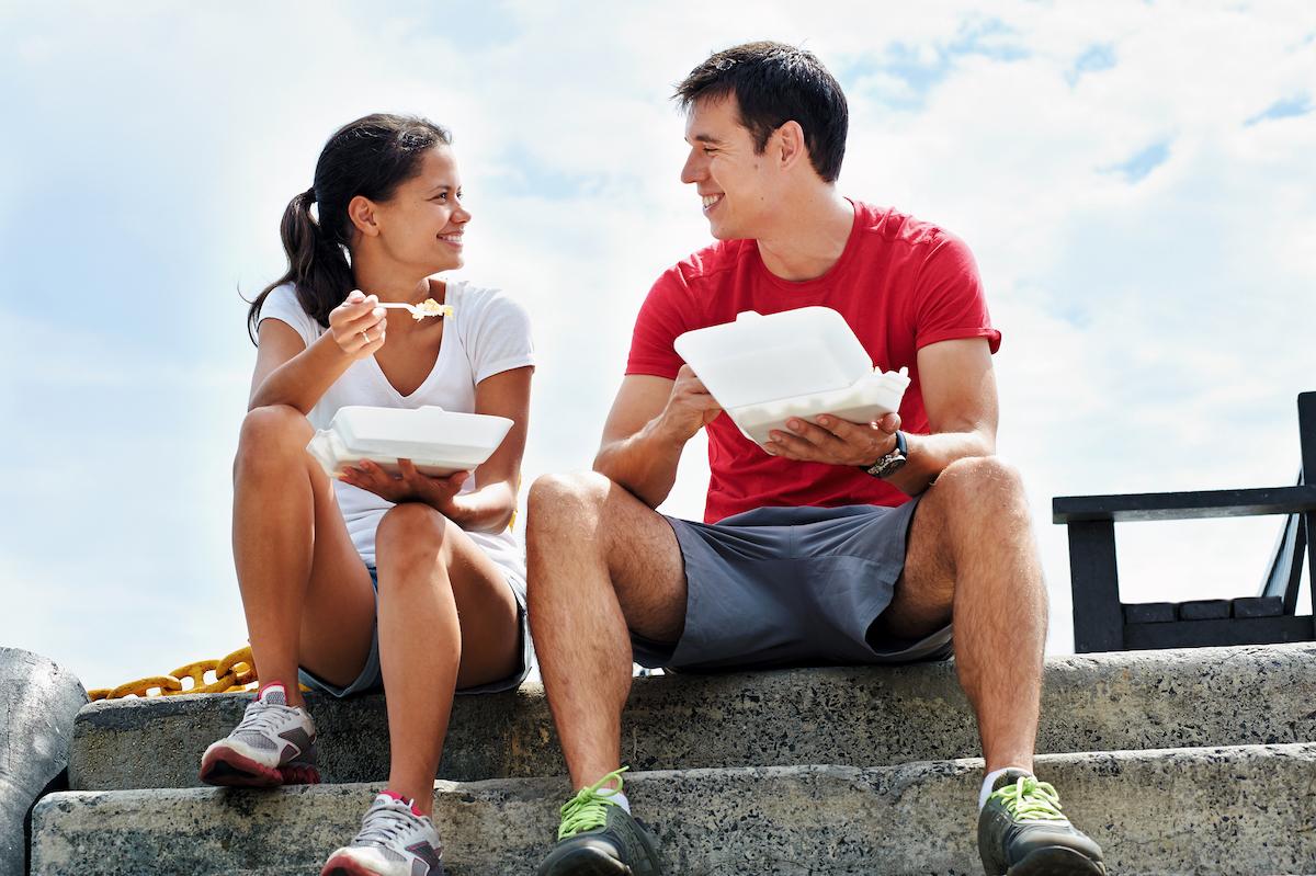 femme et homme sportifs en train de manger après une séance d'entrainement