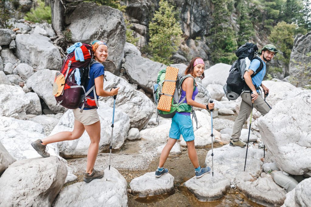 Groupe de randonneuses et randonneur traversant une rivière à la montagne