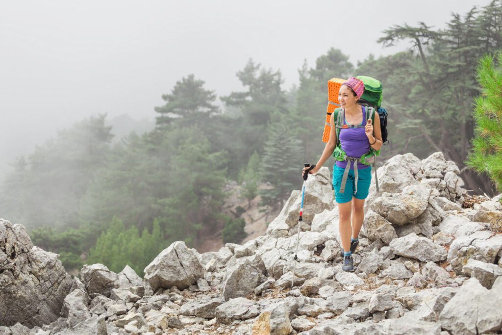 Jeune femme faisant de la randonnée en montagne par temps brumeux