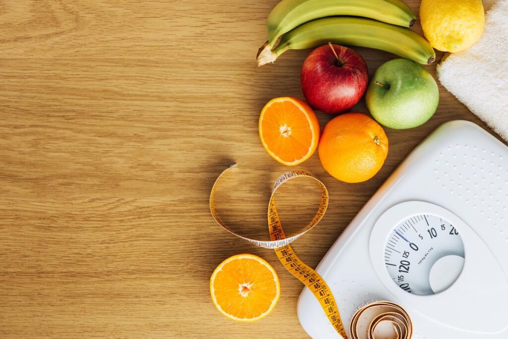 Fruits, pèse personne et mètre ruban pour stabiliser après perte de poids
