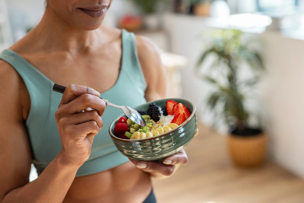 Jeune femme mangeant des fruits pour faire le plein d'énergie