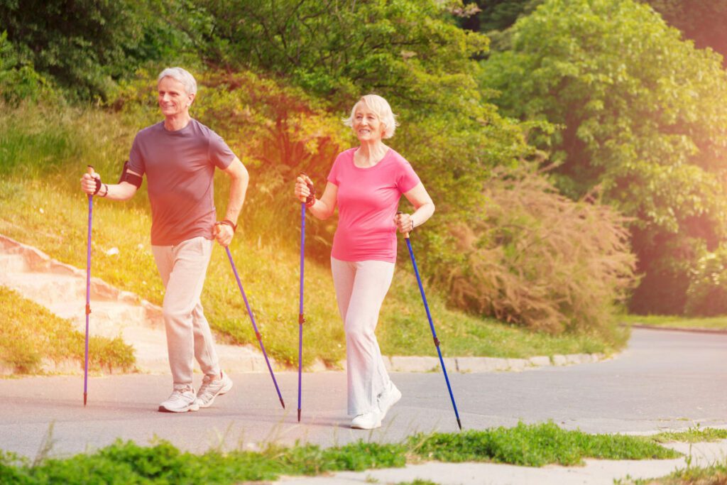 Couple de senior en train de marcher avec des bâtons
